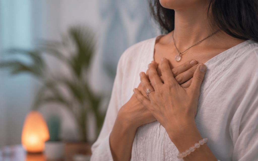 A woman resting her hands on her chest in a heart-centered breathing practice